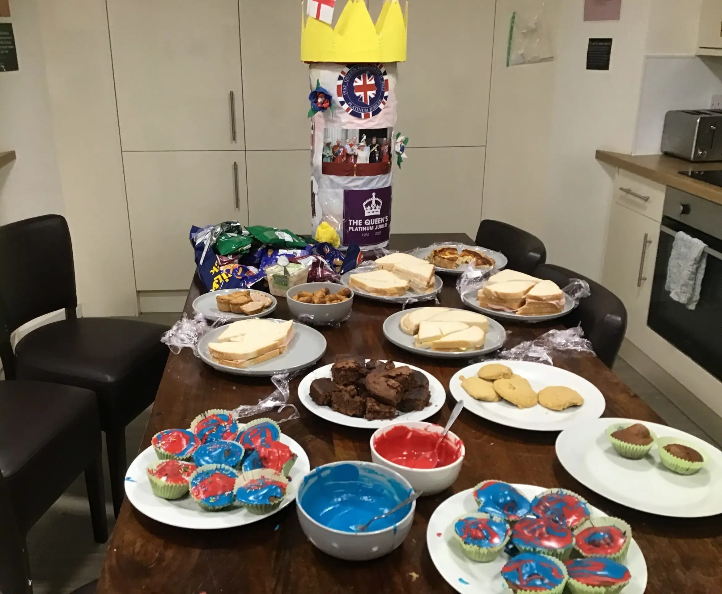table full of cakes, sandwiches, and biscuits