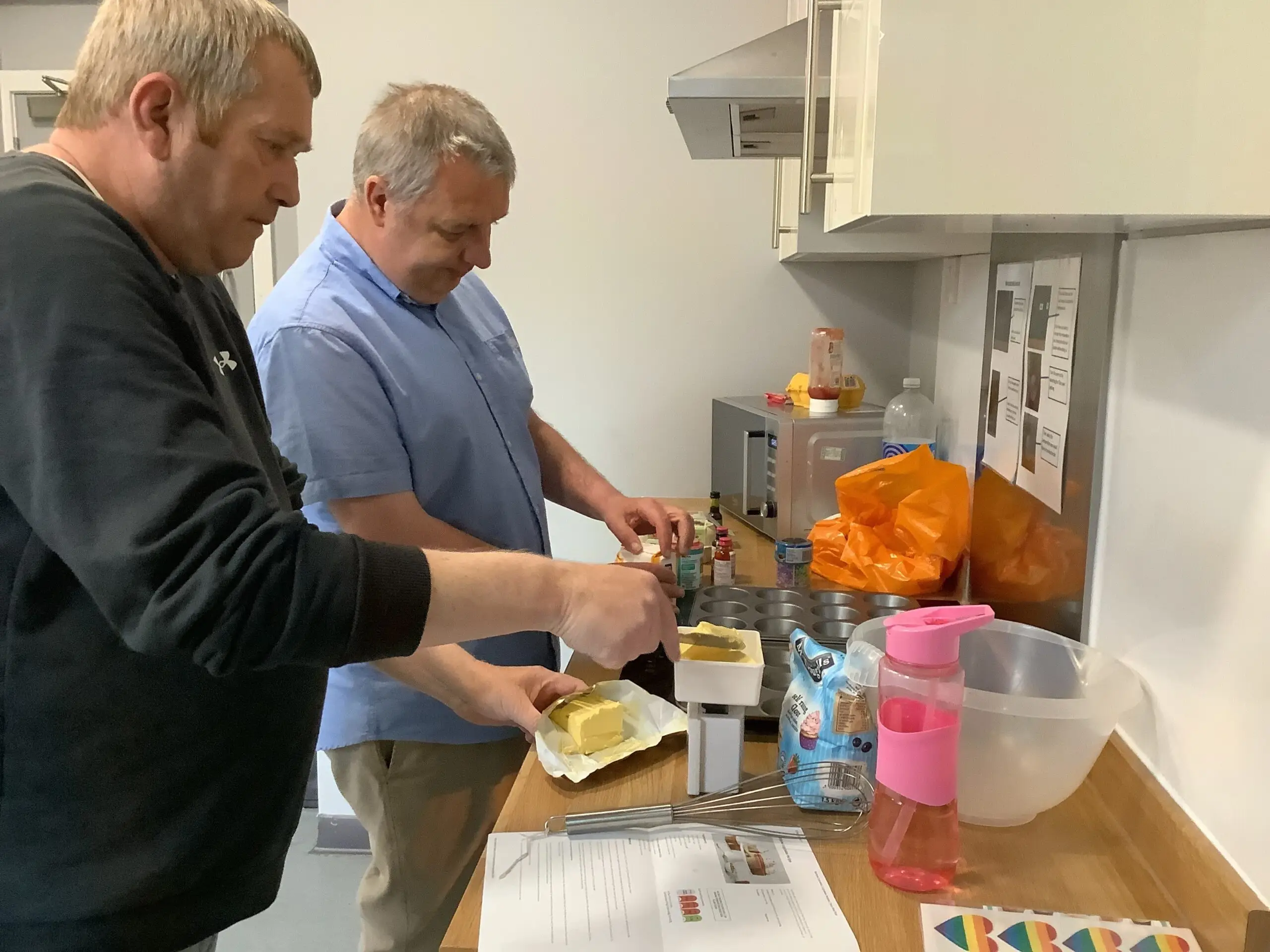 two males making cupcakes