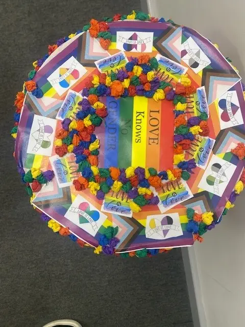post box lid decorated with rainbows and pom poms