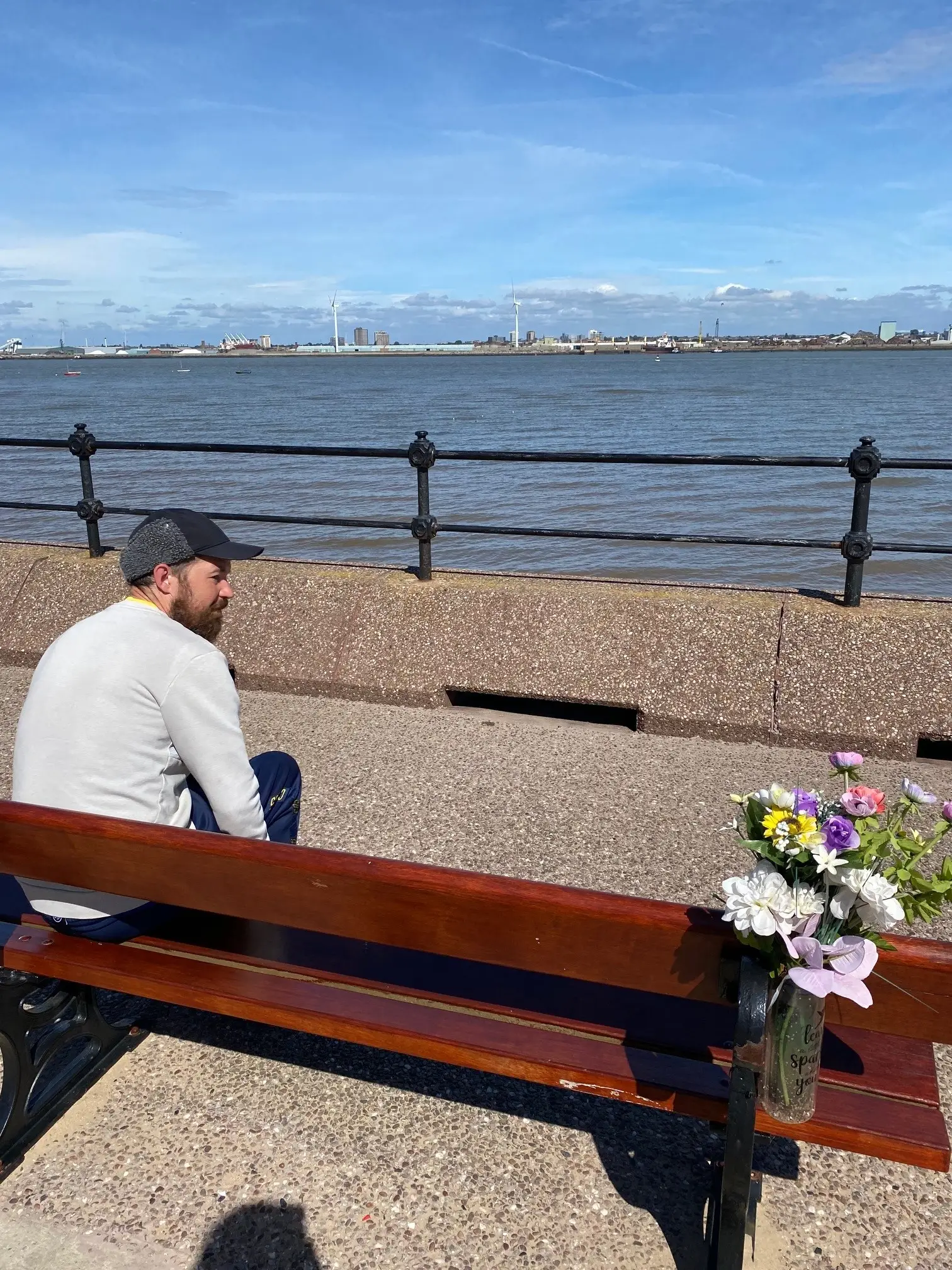 resident sitting on bench looking out to sea