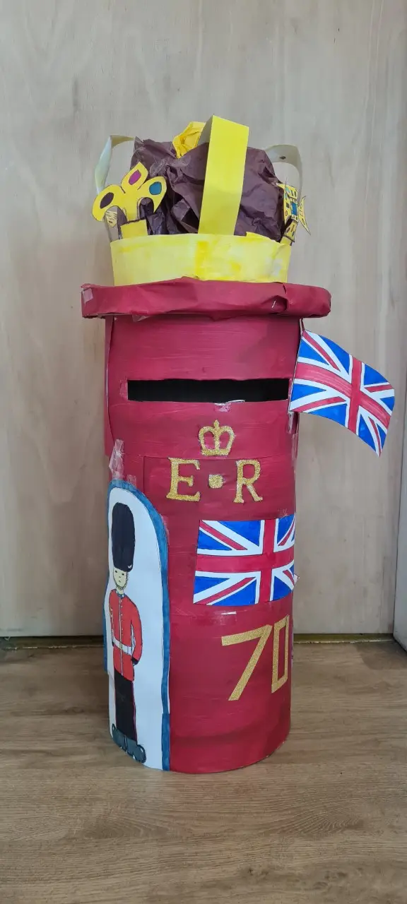 postbox decorated with crown, union jack flags and painting of soldier