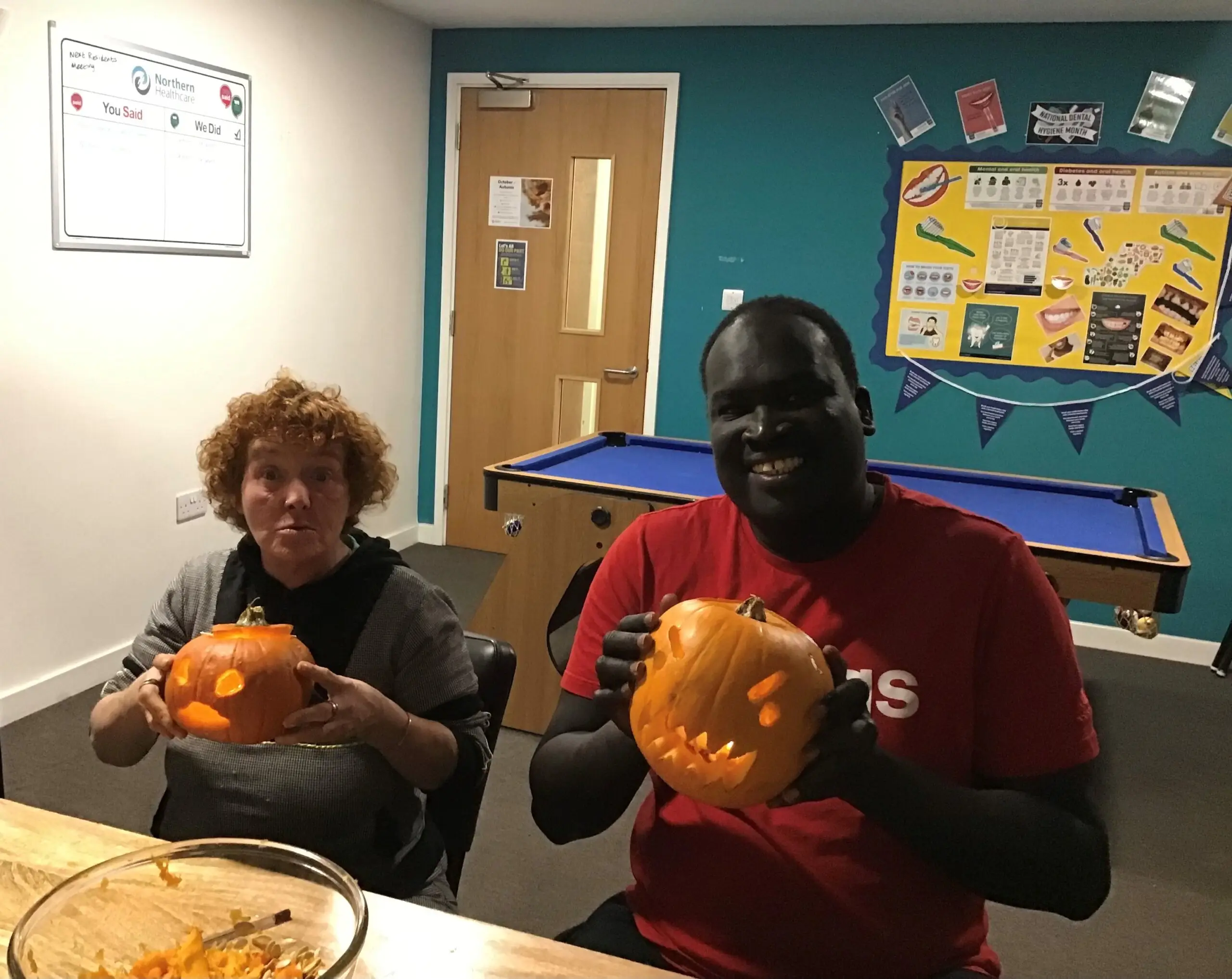 two residents proudly holding their carved pumpkins