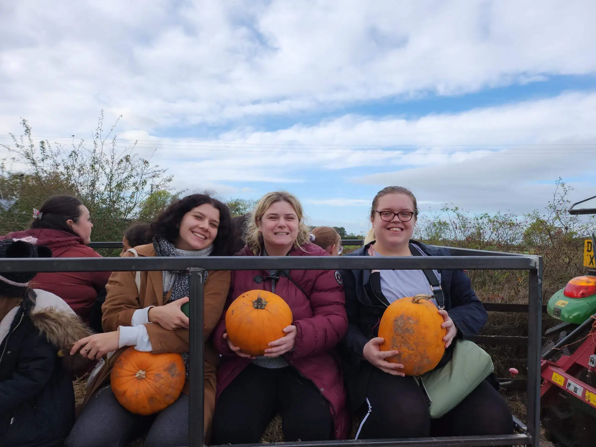 Thress residents holding pumpkins