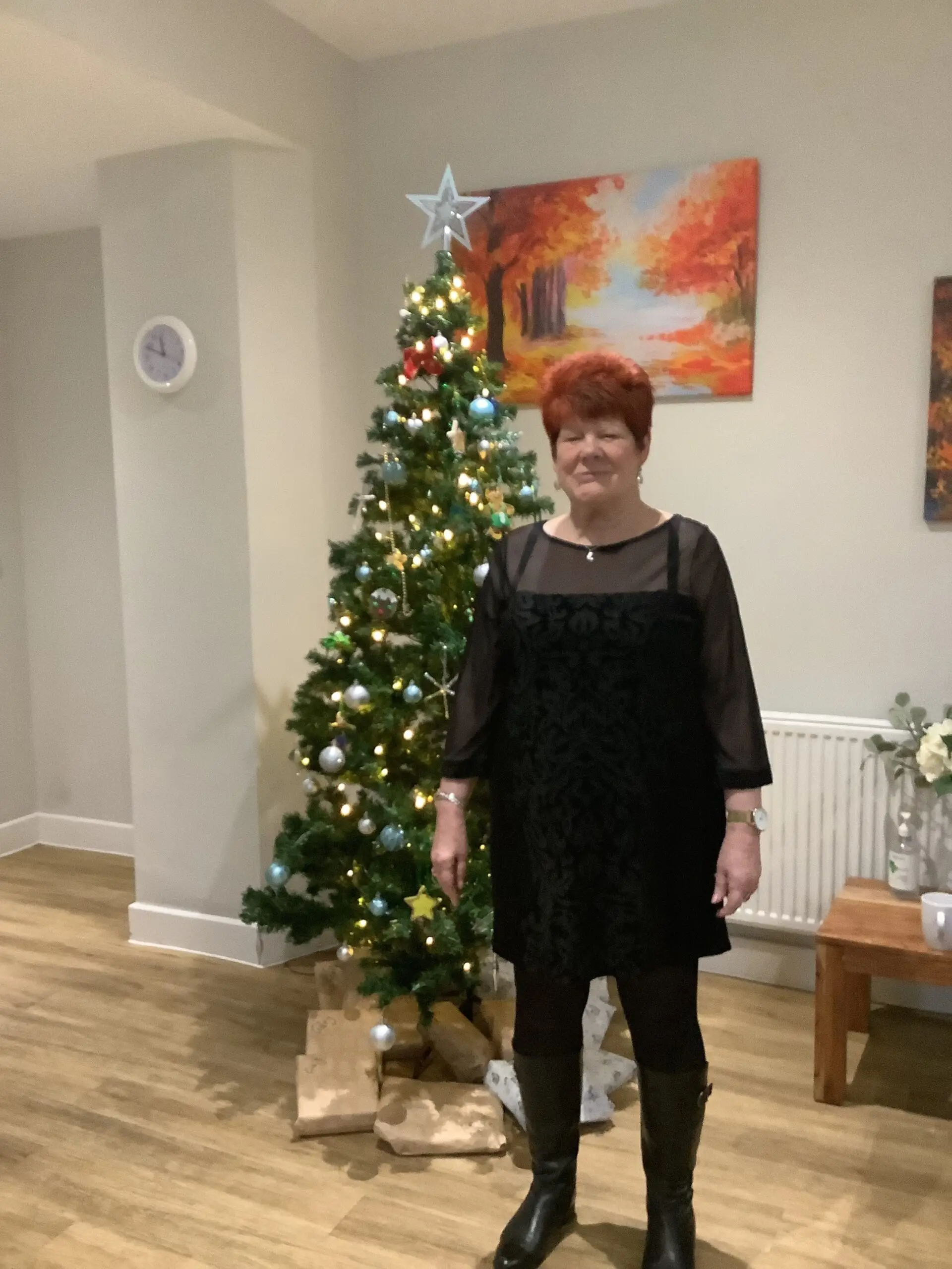 resident in front of christmas tree