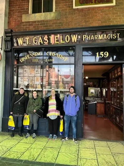 Four residents outside old fashioned pharmacy