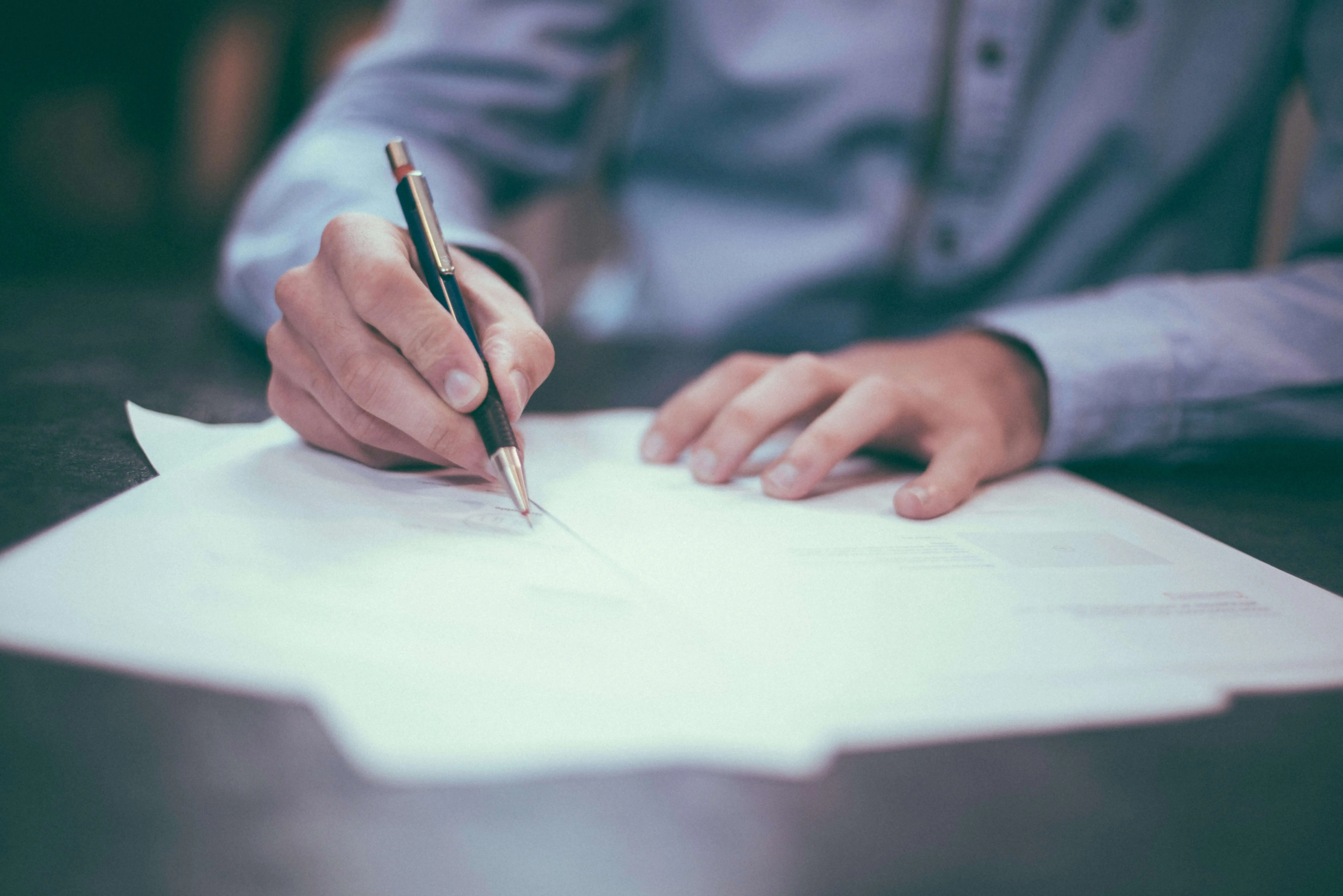 Business man writing papers in relation to a lack of suitable supported accommodation for mental health hospital patients.