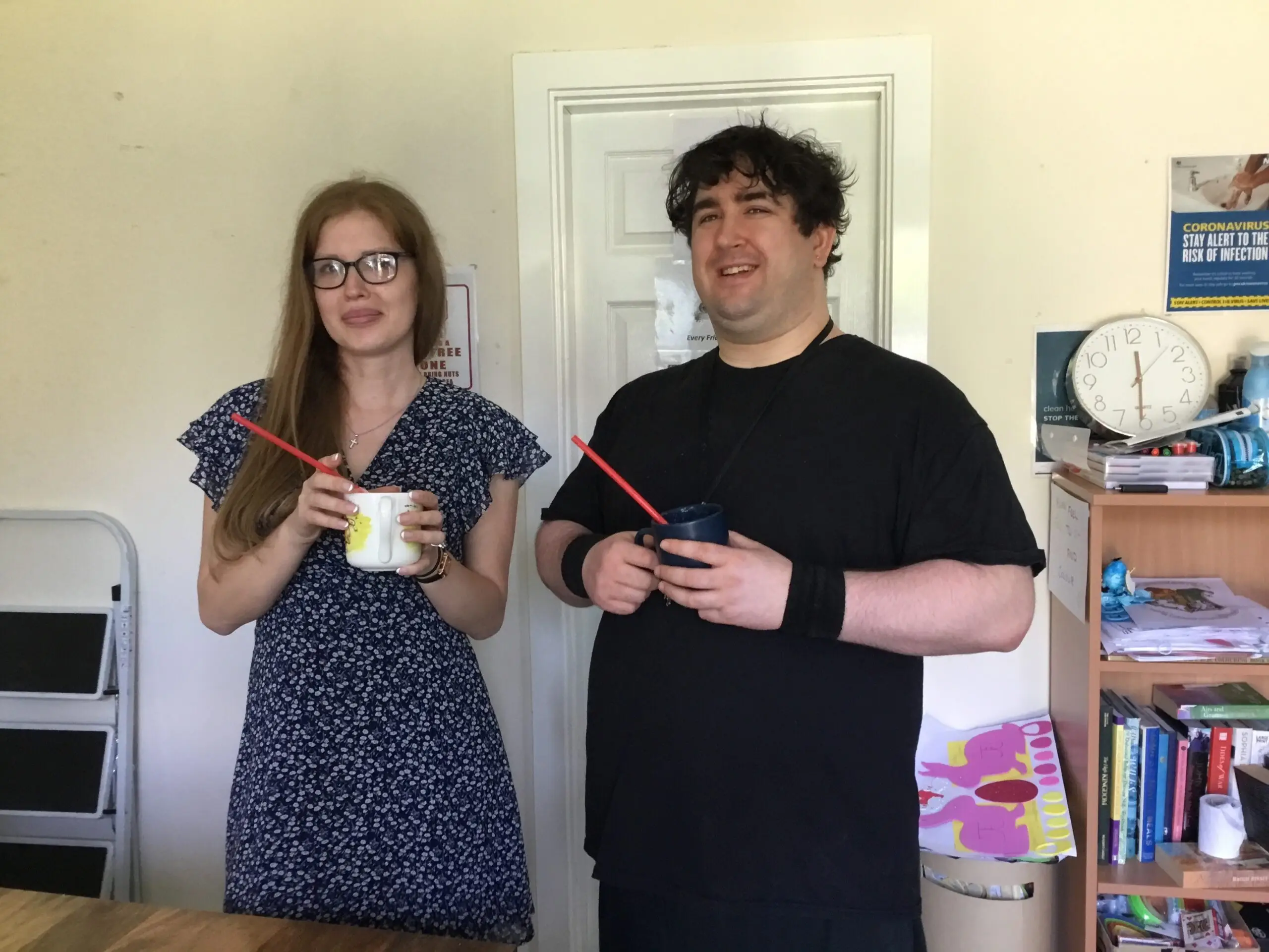 male and female holding drinks cup