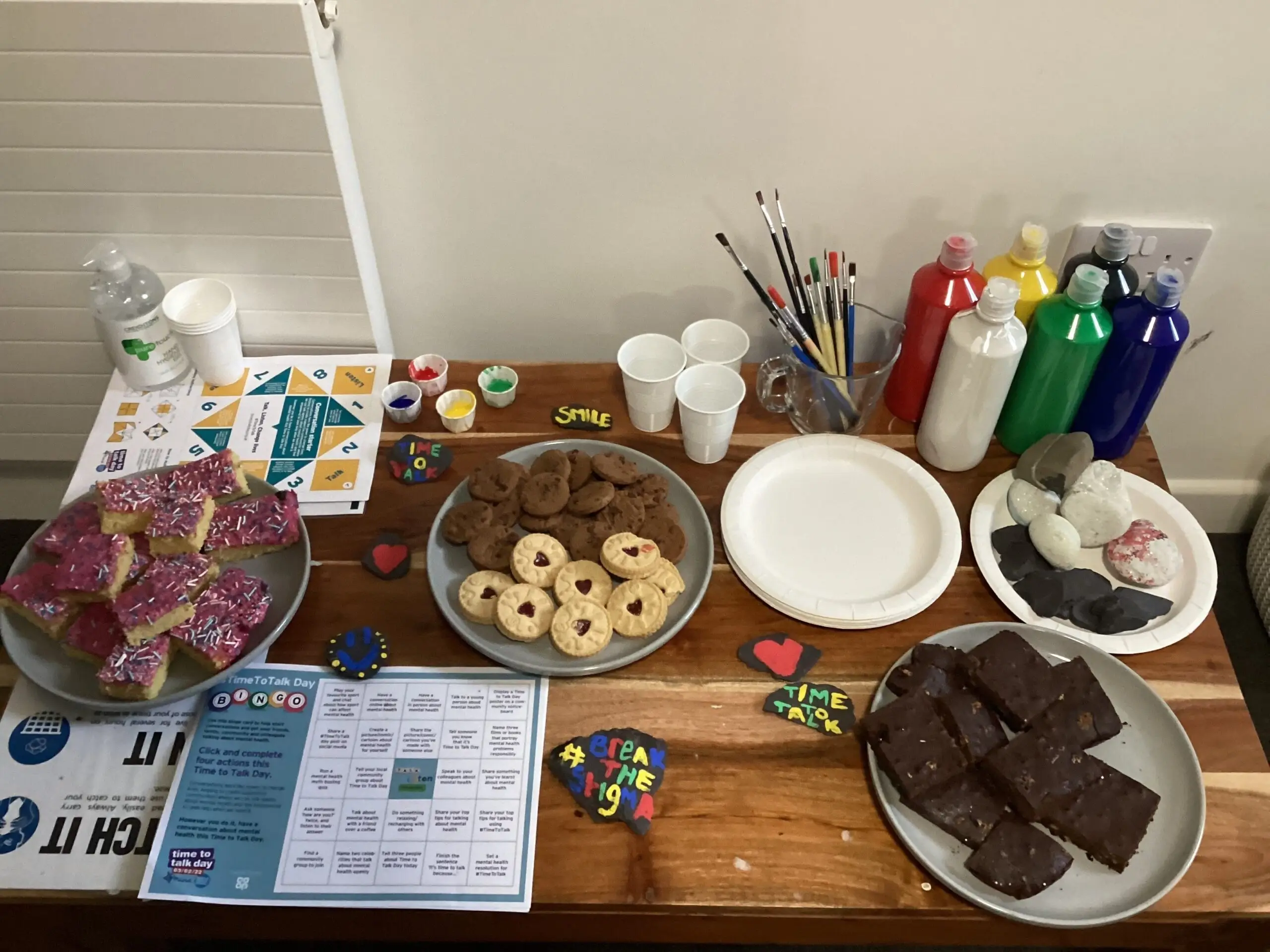 cakes, biscuits and paint pots and paintbrushes on table