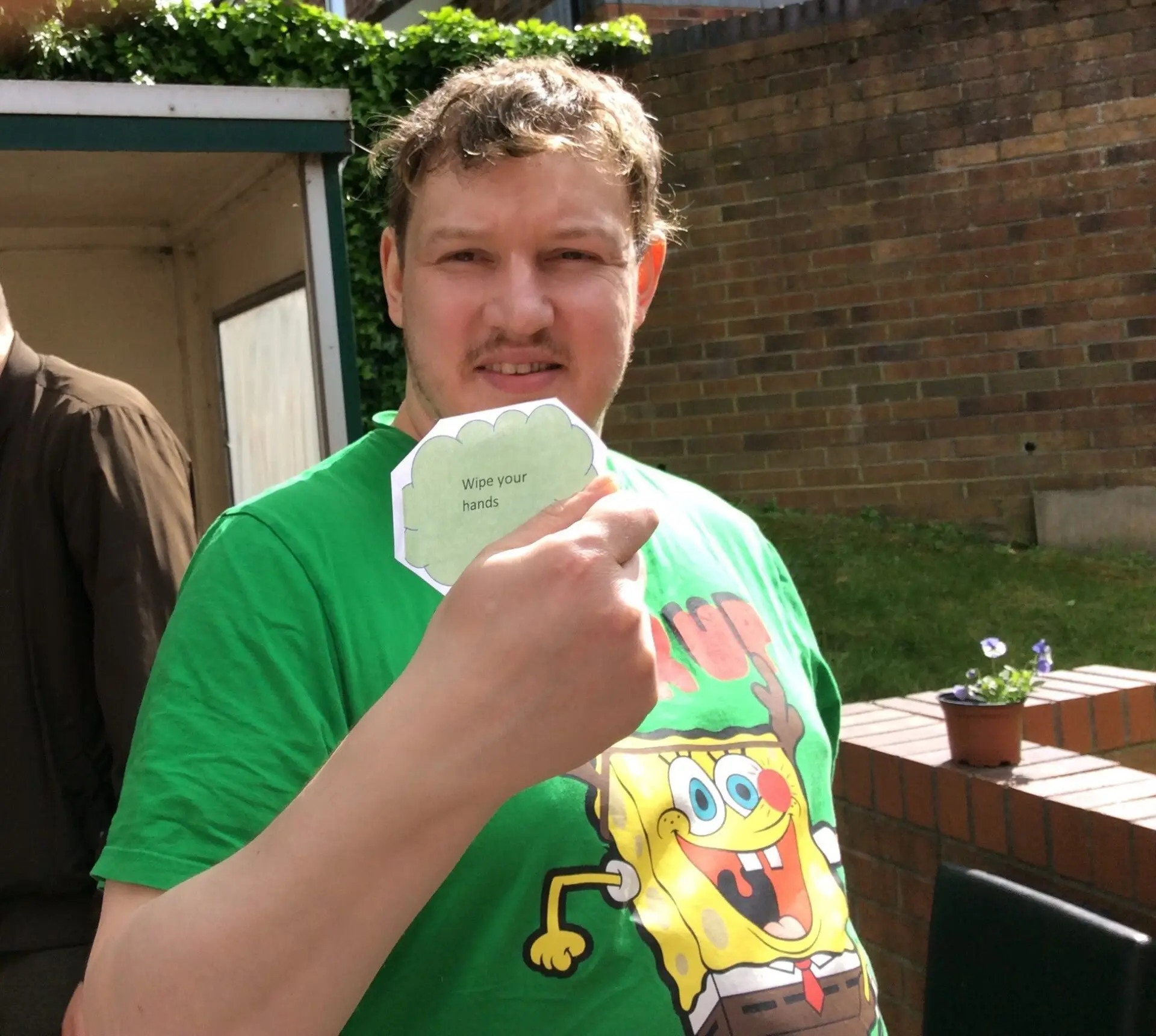 resident in green tshirt holding treasure hunt clue