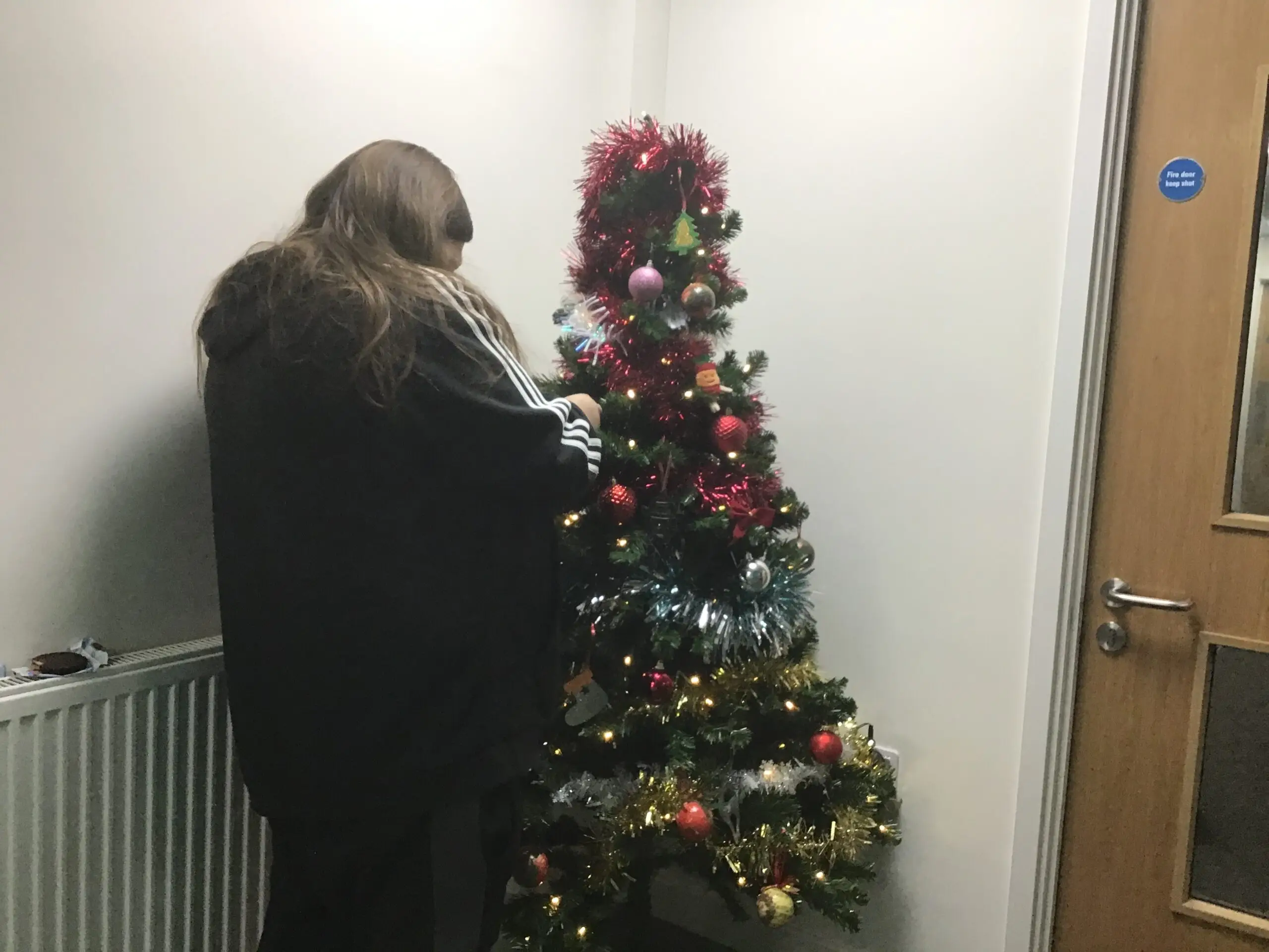 resident putting baubles on Christmas tree
