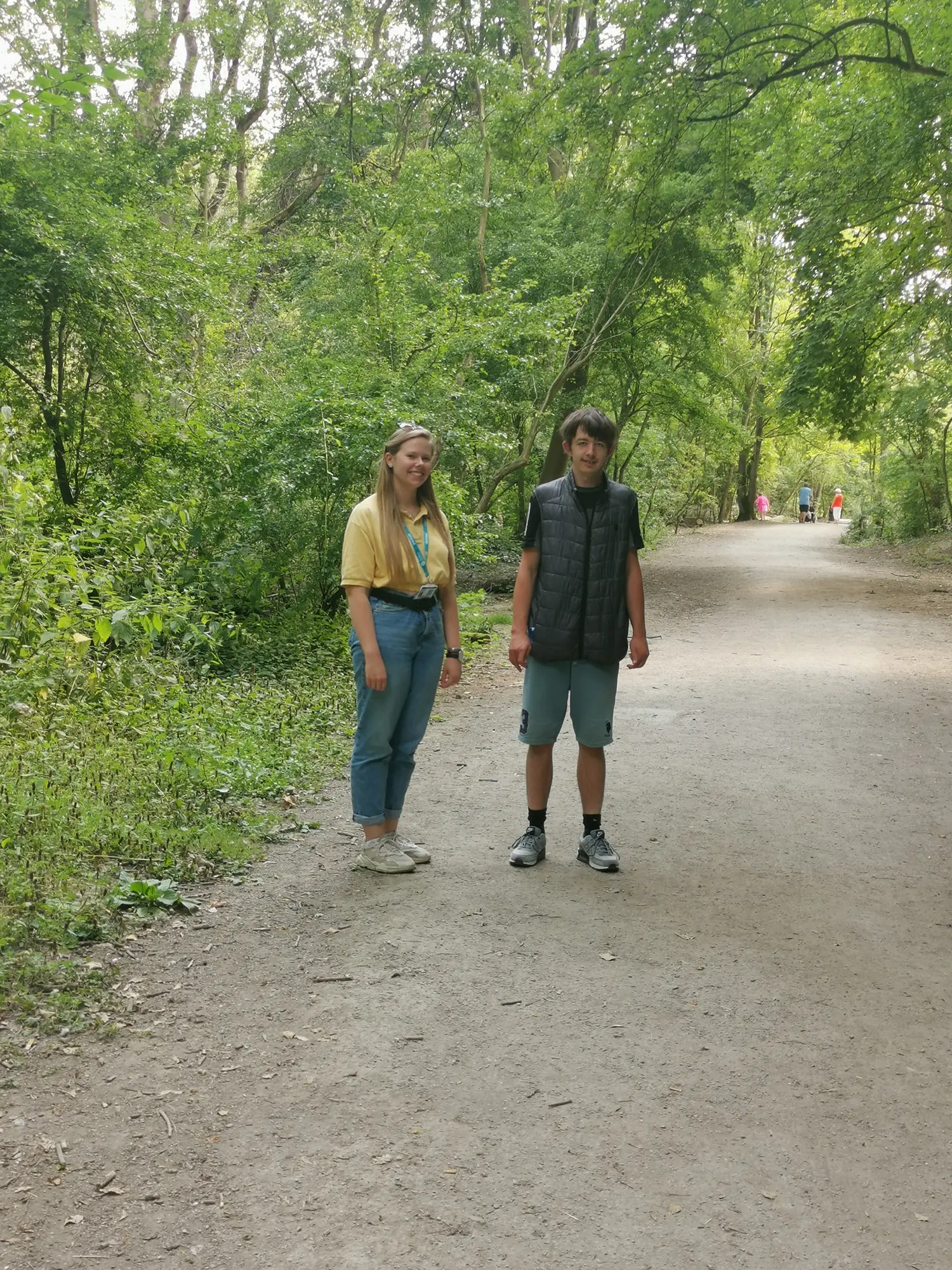 male and female on gravel path among green trees