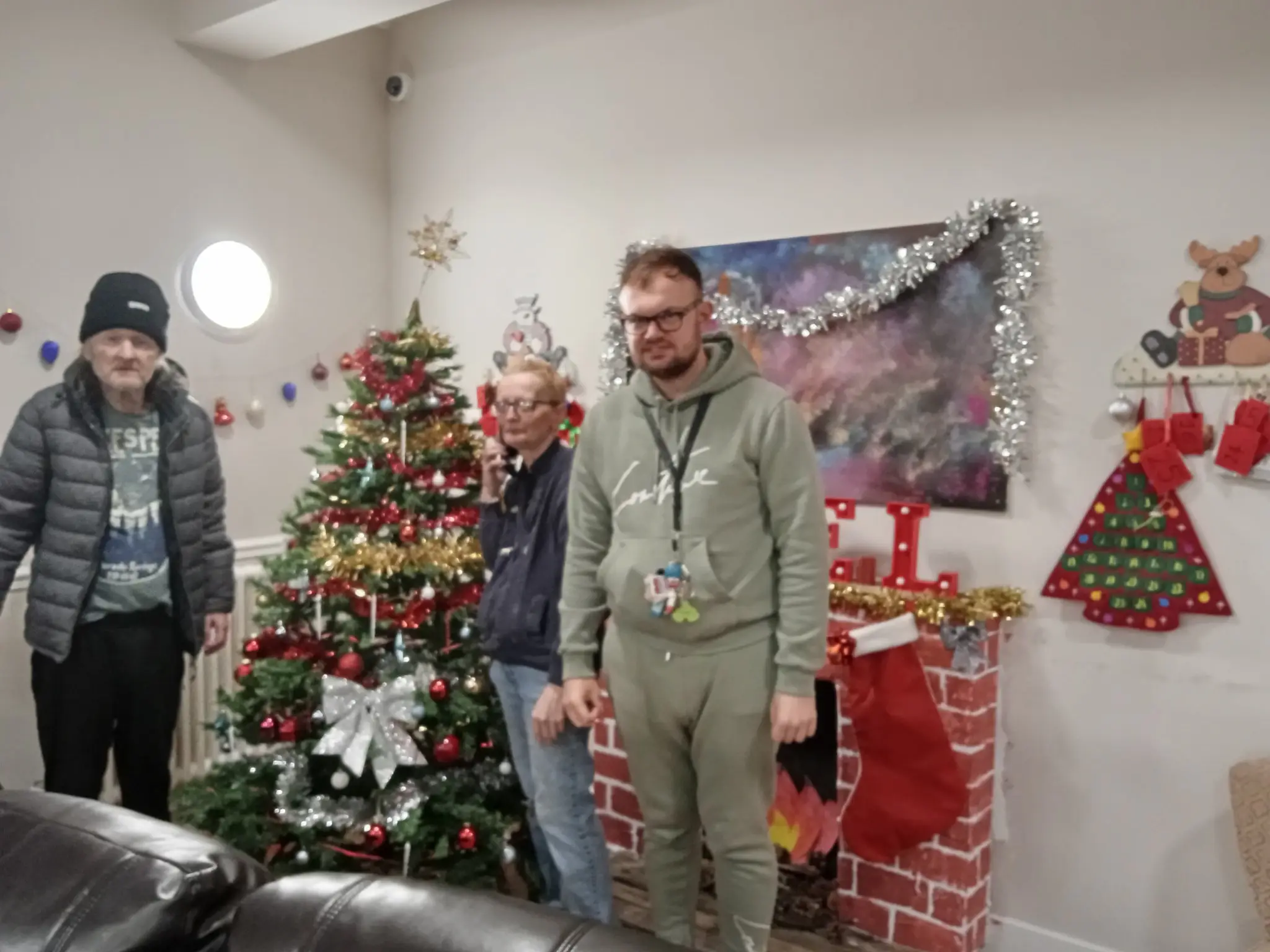 residents standing next to Christmas tree