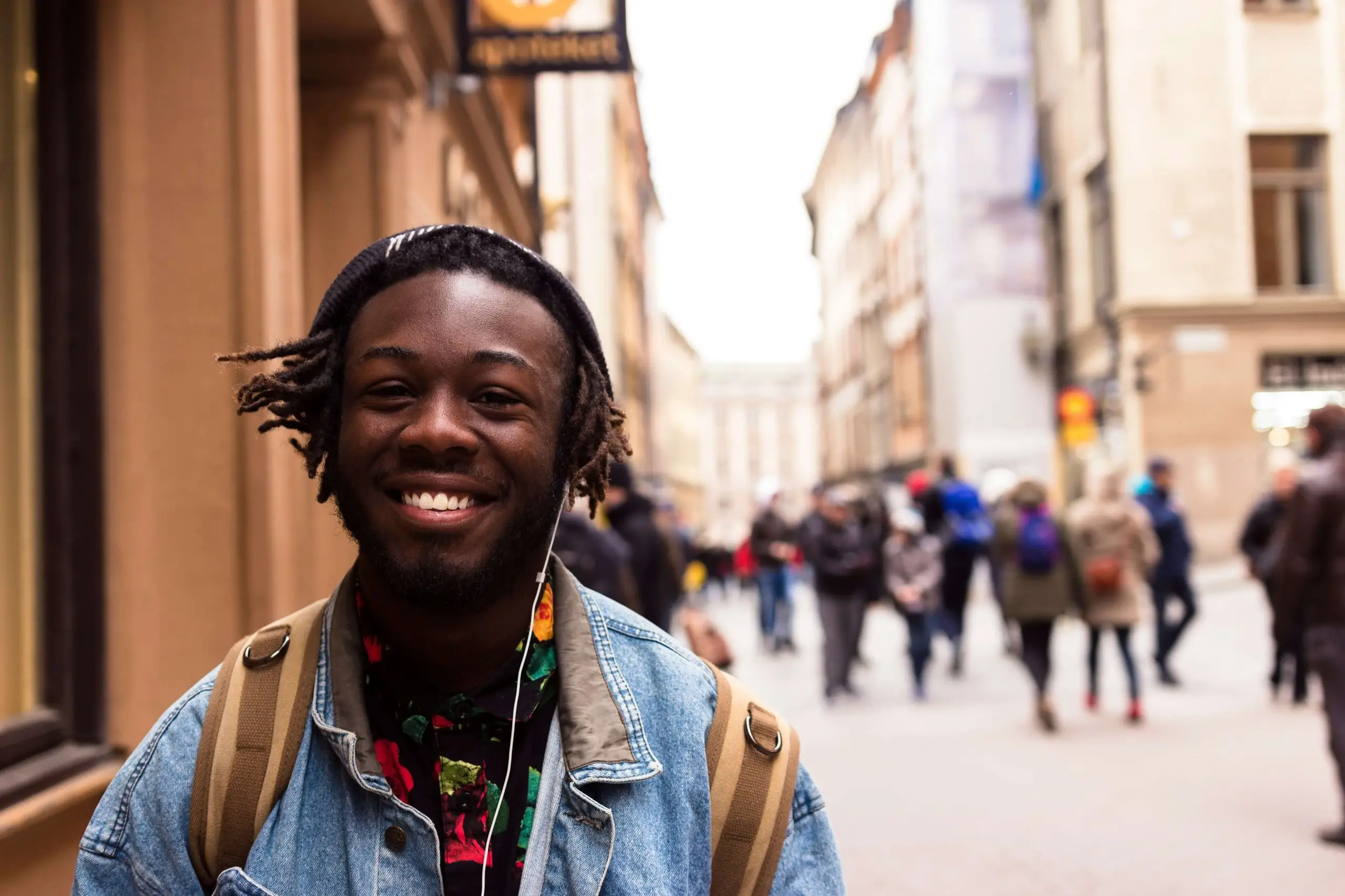 Man listening to music whilst walking down the street to make him happy, and boost his mental health and well-being.